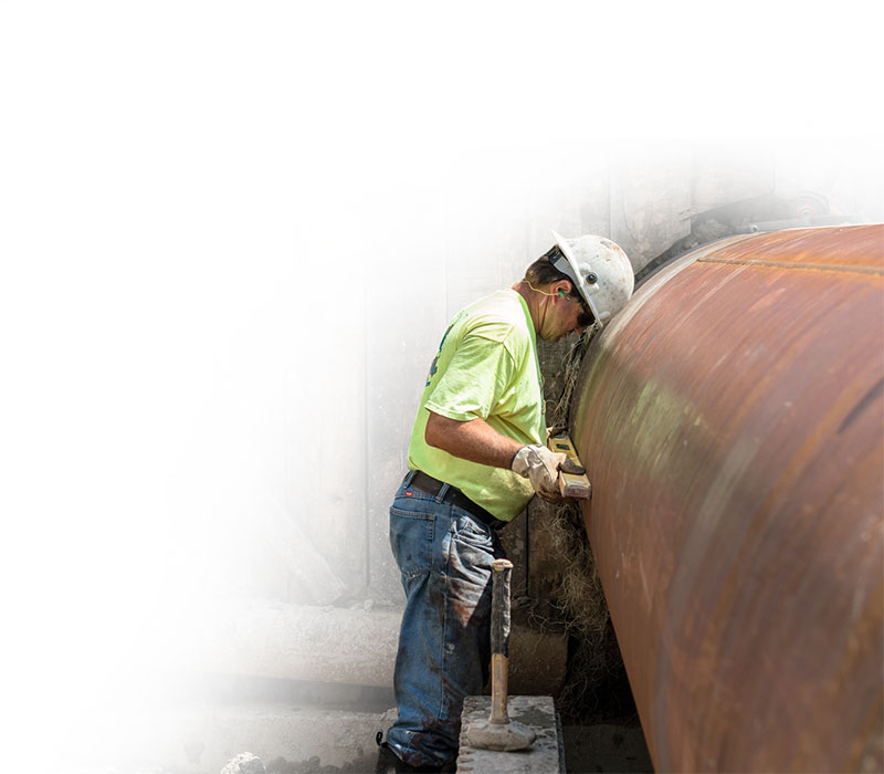Man standing next to large pipe
